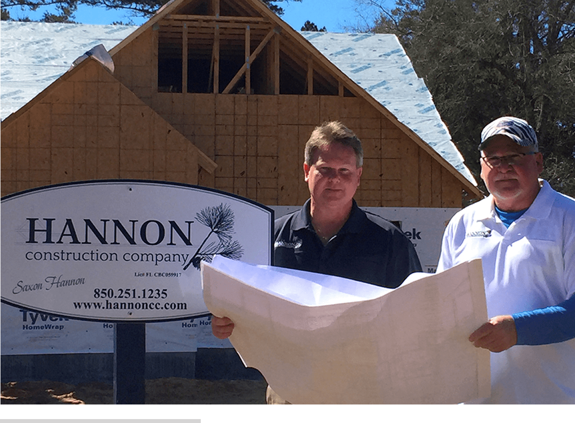 Two men in front of house under construction