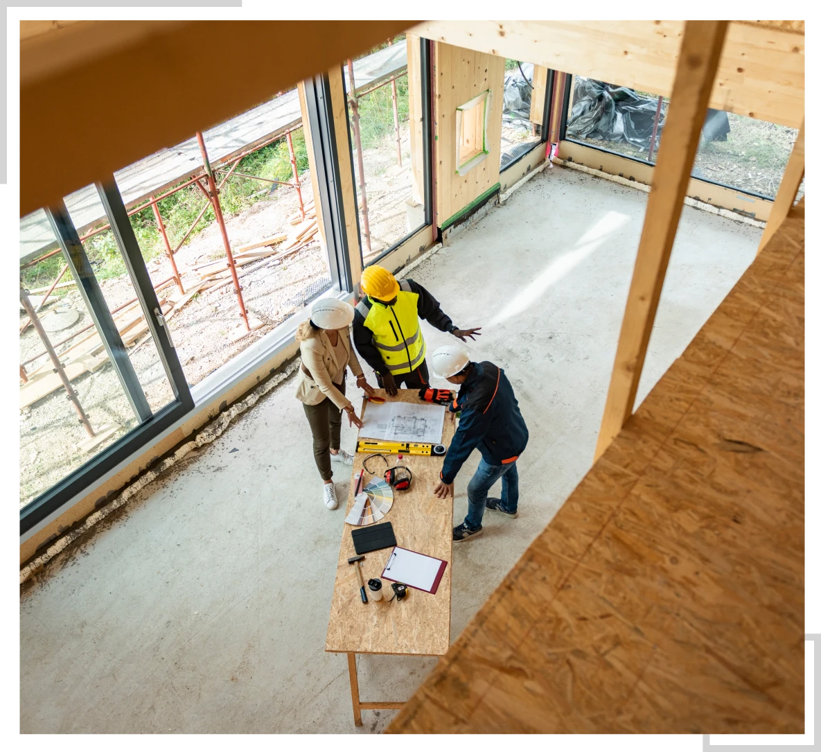 Group meeting over blueprints in construction area.