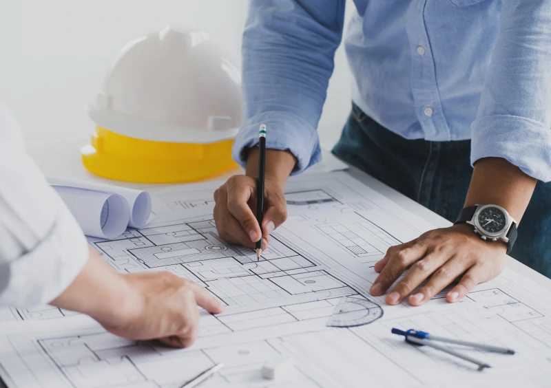 Engineers discussing architectural blueprints
